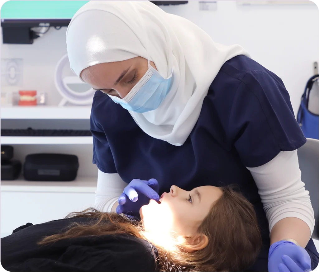 dr dana bader with patient - Snö Clinics | Abu Dhabi Snö Orthodontist guiding a patient on proper retainer care and maintenance.